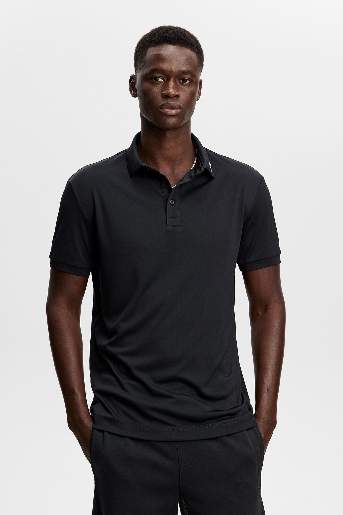 J.Lindeberg KV Print Polo Black – vista frontale che mostra il colletto a costine e l'abbottonatura a tre bottoni