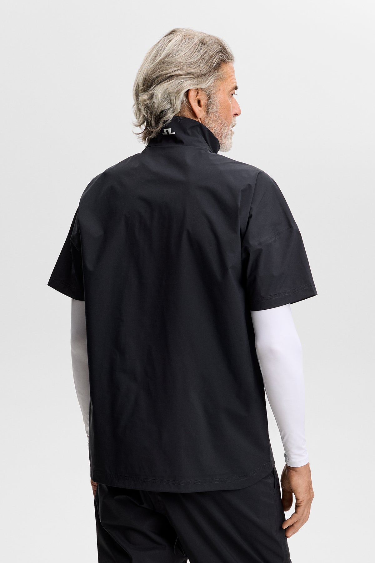 J.Lindeberg Shay Rain Shirt Black – vista laterale che mostra la silhouette aerodinamica e il marchio